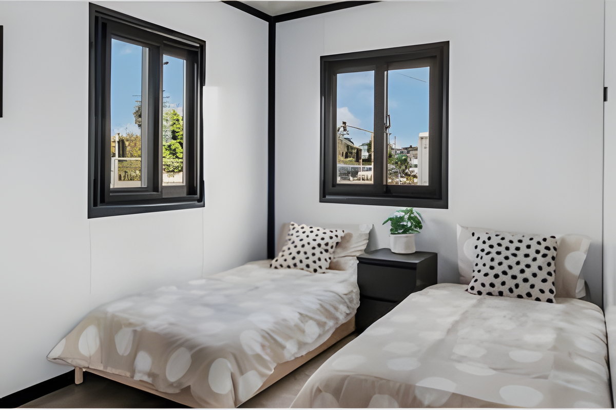 Recámara con dos camas en una casa modular AVITA